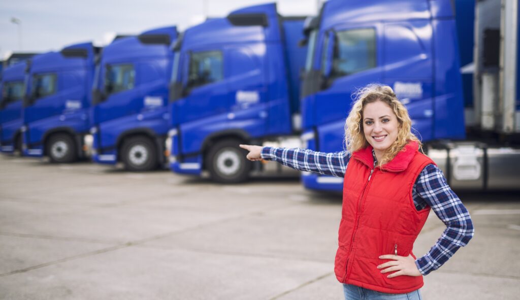 Motorista PX | female trucker standing front parked trucks pointing her finger transportation vehicles4 mulher caminhoneira